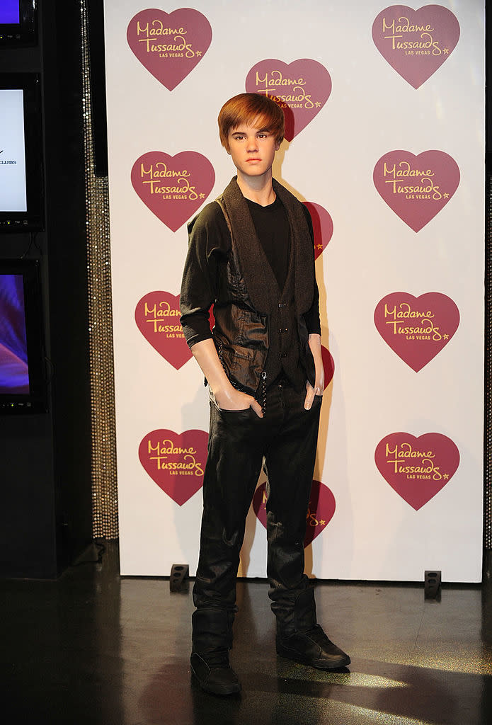 Wax figure of Justin Bieber at Madame Tussauds, wearing a black outfit and boots, standing with hands in pockets