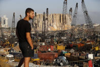 A man looks at the scene of Tuesday's explosion that hit the seaport of Beirut, Lebanon, Friday, Aug. 7, 2020. Rescue teams were still searching the rubble of Beirut's port for bodies on Friday, nearly three days after a massive explosion sent a wave of destruction through Lebanon's capital. (AP Photo/Hussein Malla)