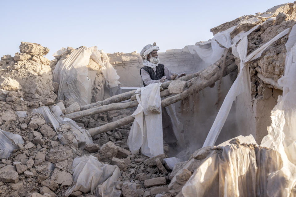 A man cleans up rubble after an earthquake in Zenda Jan district in Herat province, western Afghanistan, Wednesday, Oct. 11, 2023. Another strong earthquake shook western Afghanistan on Wednesday morning after an earlier one killed more than 2,000 people and flattened whole villages in Herat province in what was one of the most destructive quakes in the country's recent history. (AP Photo/Ebrahim Noroozi)