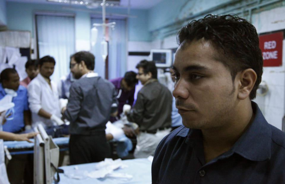 In this Thursday, July 26, 2012 photo, Amarjeet Singh, right, stands guard inside the emergency room at the Deen Dayal Upadhyay Hospital in New Delhi, India. Singh and 20 other bouncers have been hired to protect doctors as well as keep the emergency and labor rooms from filling up with patients’ often agitated relatives and friends. (AP Photo/Nasr ul Hadi)