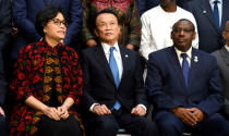 Japan's Finance Minister Taro Aso (C) joins Indonesia's Finance Minister Sri Mulyani Indrawati (L) and Rwanda's Finance Minister Claver Gatete as they take their seats for a "family" photo for the International Monetary and Financial Committee (IMFC), as part of the IMF and World Bank's 2017 Annual Spring Meetings, in Washington, U.S., April 22, 2017. REUTERS/Mike Theiler