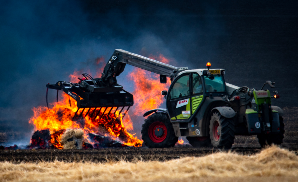 <em>The field fire started at about 11.30am when temperatures went past 26C as farmers at Moulton Manor Farms were bailing straw (SWNS)</em>