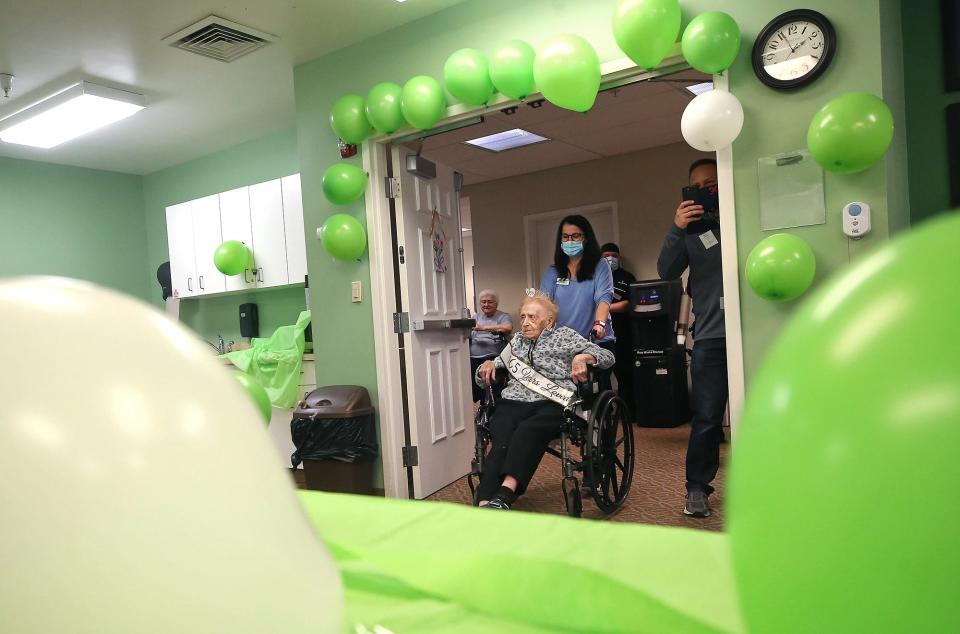 Helen Molnar, 105,  is wheeled into the activities room on Tuesday for birthday bingo at The Landing of Stow.