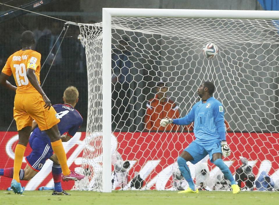 Japan's Keisuke Honda shoots to score a goal past Ivory Coast's Boubacar Barry during their 2014 World Cup Group C soccer match at the Pernambuco arena in Recife, June 14, 2014. REUTERS/Stefano Rellandini