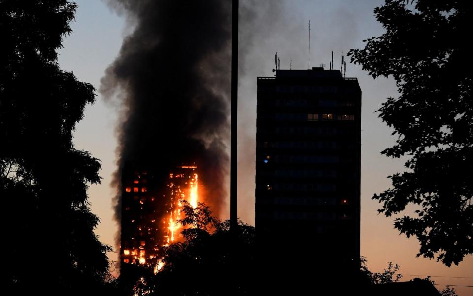 Flames and smoke billow as firefighters deal with a serious fire in a tower block at Latimer Road - Credit: Reuters