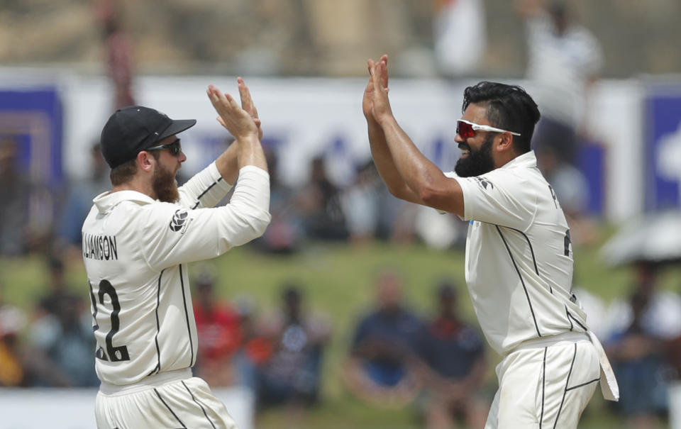 New Zealand's Ajaz Patel, right, is congratulated by Kane Williamson for the dismissal of Sri Lankan's Kusal Mendisduring the day five of the first test cricket match between Sri Lanka and New Zealand in Galle, Sri Lanka, Sunday, Aug. 18, 2019. (AP Photo/Eranga Jayawardena)