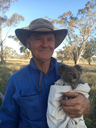 Australian farmer Robert Frend holds a young joey koala on his property in Gunnedah, Australia, in this September 2016 handout image. George Madani/Handout via REUTERS