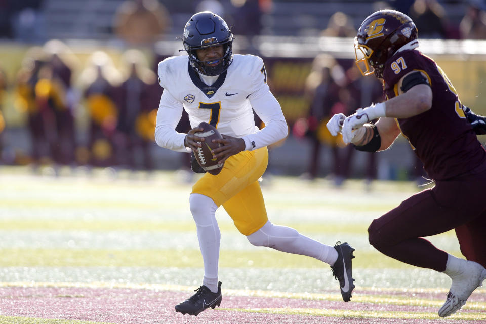 Toledo quarterback Dequan Finn, left, scrambles against Central Michigan defensive lineman Michael Heldman (97) during the second half of an NCAA college football game, Friday, Nov. 24, 2023, in Mount Pleasant, Mich. (AP Photo/Al Goldis)