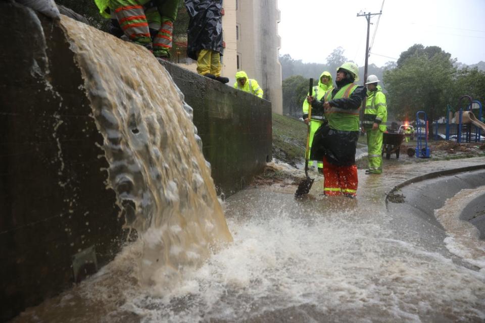 Workers try to divert water into drains in Marin City (Getty Images)