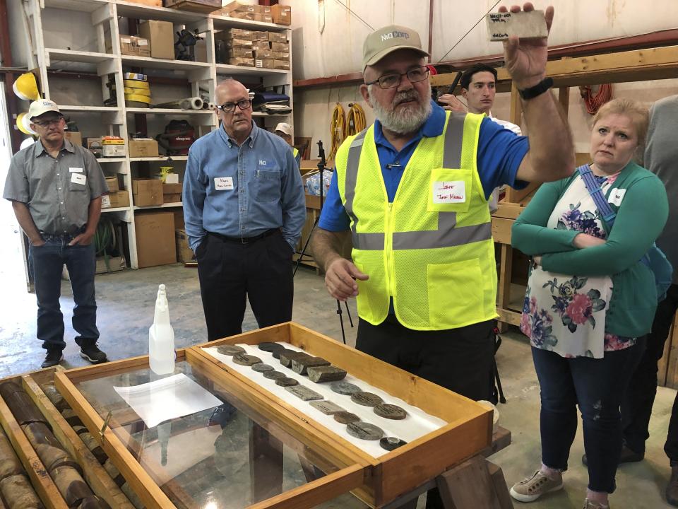 NioCorp Corporate Controller Jeff Mason shows investors a rock sample while the company's CEO Mark Smith listens, Oct. 6, 2021 in Elk Creek, Neb. The company hopes to build a mine in southeast Nebraska to extract rare minerals if it can raise $1 billion. (AP Photo/Josh Funk)