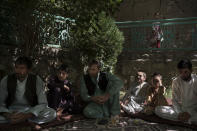Painda Mohammed, left, sits with family members at their house's yard near Kabul, Afghanistan, Friday, Sept. 17, 2021. Painda's son, Fida Mohammad died after falling from a departing U.S. Air Force C-17 taking off from Kabul’s International Airport. (AP Photo/Felipe Dana)