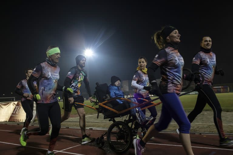 Sammy Basso, center, trains with his runners club, a group of friends and fans who run marathons to support awareness of his disease of progeria, in Bassano del Grappa, Italy, March 10, 2022. Basso, 26, is believed to be the oldest surviving person with Hutchinson-Gilford Progeria syndrome, and with his degrees in natural science and molecular biology is helping with research efforts to discover a treatment and the secrets of aging. (Nadia Shira Cohen/The New York Times)