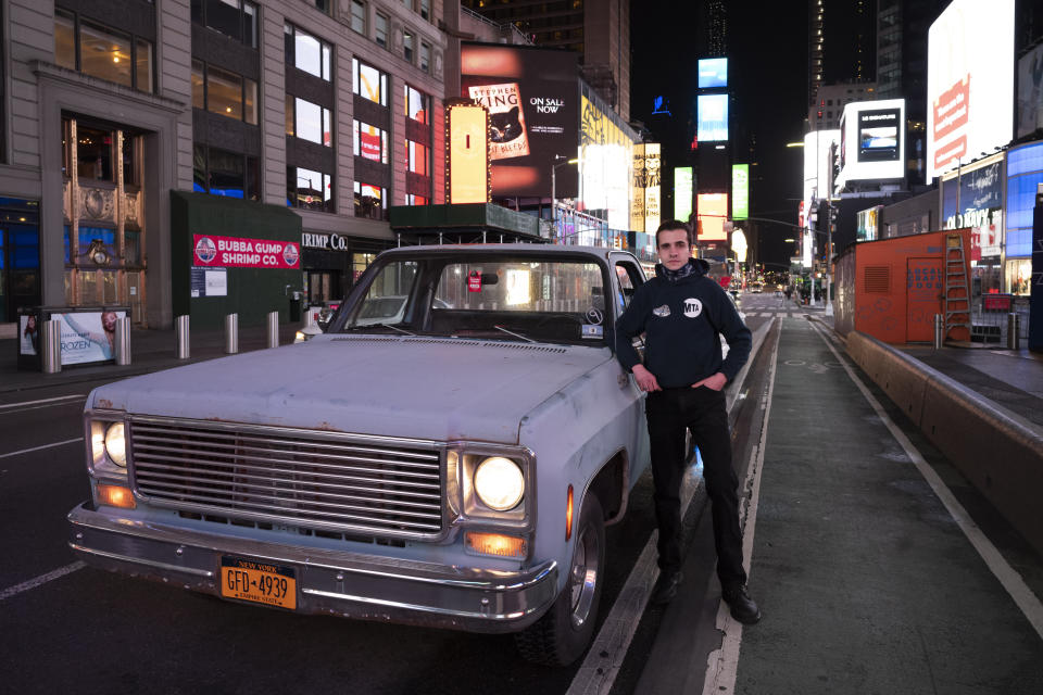 In this April 29, 2020 photo, Mike Hodurski poses with his 1977 Chevy pickup in New York's Times Square during the coronavirus pandemic. "It's a lot of fun. Might as well take advantage of it now, while nobody's over here," Hodurski said during a Wednesday evening visit. "The streets are dead. You'd never get to see the streets like this." (AP Photo/Mark Lennihan)