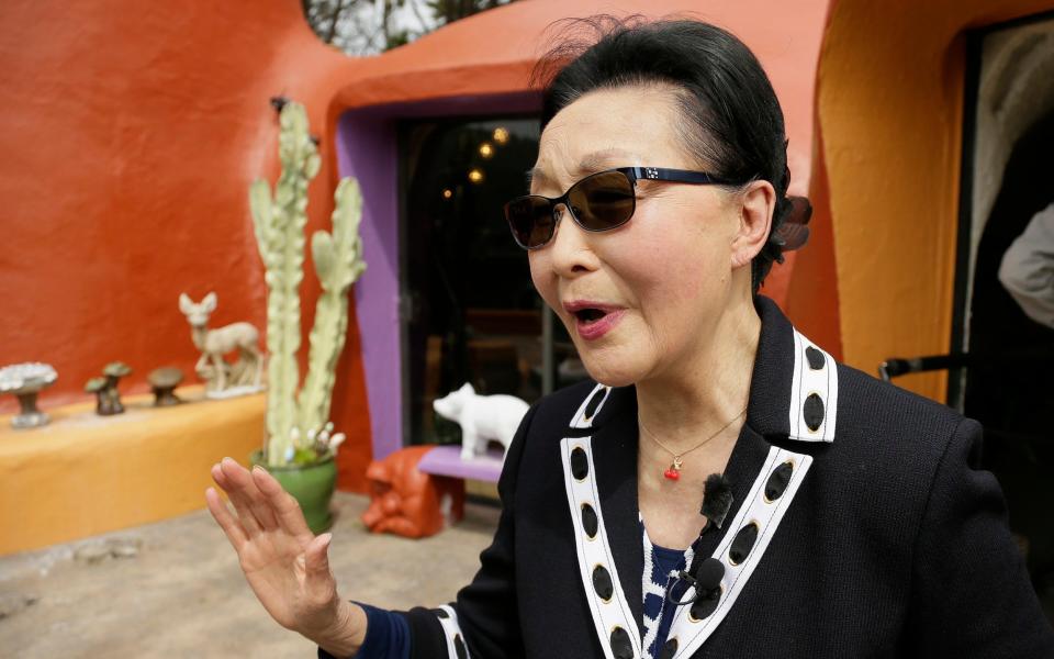 Florence Fang talks with reporters after a news conference outside her Flintstone House in Hillsborough, Calif. - AP