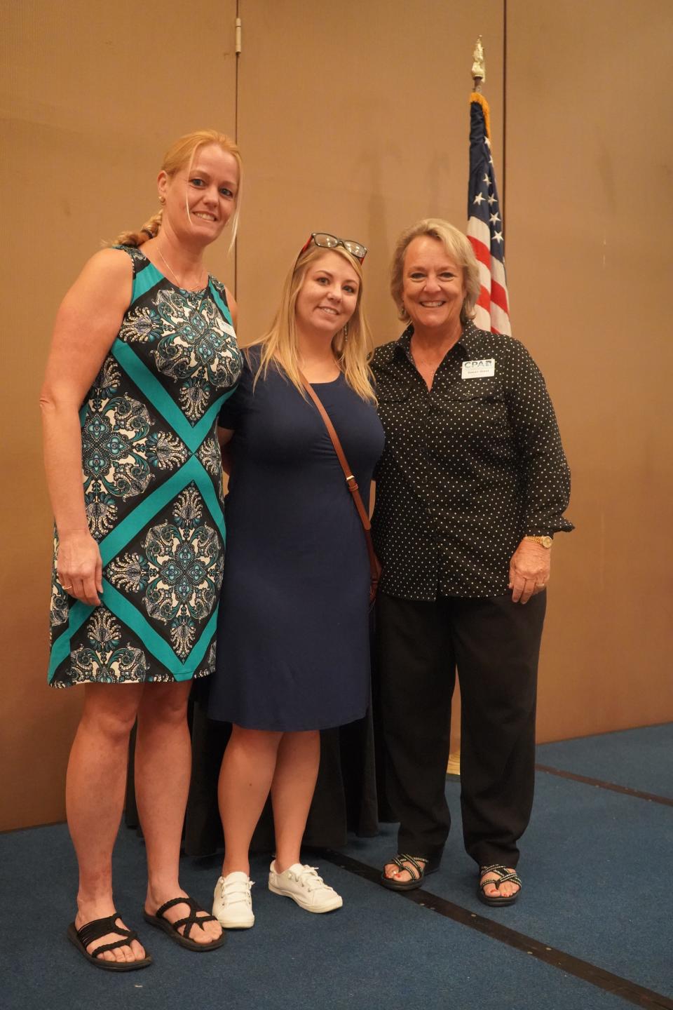 At left, Angela Klopf, executive director of Habitat for Humanity of Bay County, stands with Susan West, president of the Central Panhandle Association of Realtors, right, and Ashly Cooper, a local single mom who will be the recipient of a new Habitat home funded by CPAR.