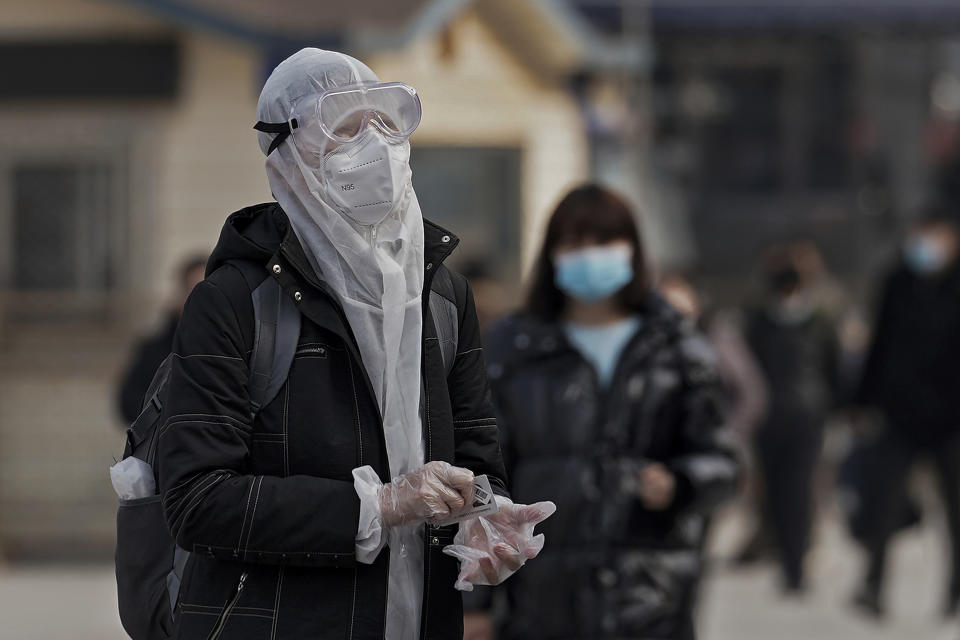 A woman wearing protective gear to help curb the spread of the coronavirus arrives at the railway station in Beijing, Wednesday, Jan. 27, 2021. China has given more than 22 million COVID vaccine shots to date as it carries out a drive ahead of next month's Lunar New Year holiday, health authorities said Wednesday. (AP Photo/Andy Wong)