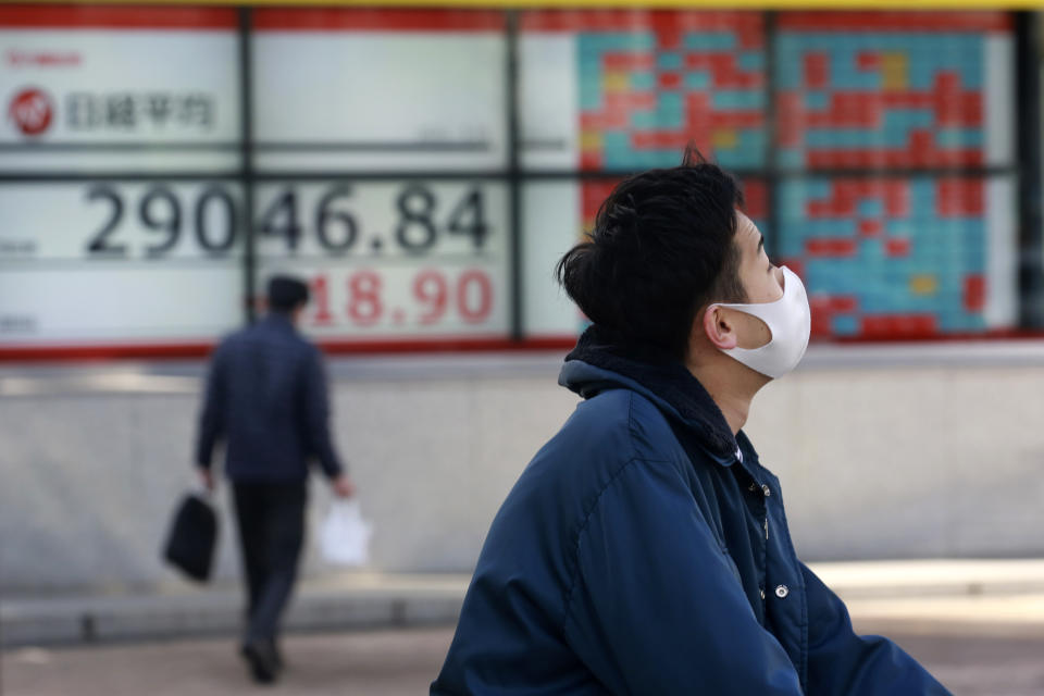 People walk by an electronic stock board of a securities firm in Tokyo, Wednesday, March 10, 2021. Shares are higher in Asia after gains for major tech companies powered a 3.7% surge in the Nasdaq, the largest jump for the index in four months. (AP Photo/Koji Sasahara)