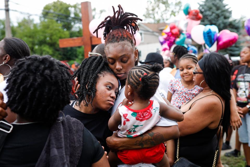 Aekeyra Tate, center, hugs her daughter Kensley King, 1 and cousin Chakiya Jones, center left, Chana Jones, left, during a community vigil on Erwin Avenue near Wynter Cole Smith of Lansing, 2, was found in Detroit on Thursday, July 6, 2023. Tate and Jones are all cousins of Almount "AJ" Smith, who is the father of Wynter Cole Smith.