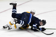 Winnipeg Jets' Neal Pionk (4) falls on Nashville Predators' Nick Cousins (21) during the second period of NHL hockey game action in Winnipeg, Manitoba, Saturday, Oct. 23, 2021. (Fred Greenslade/The Canadian Press via AP)