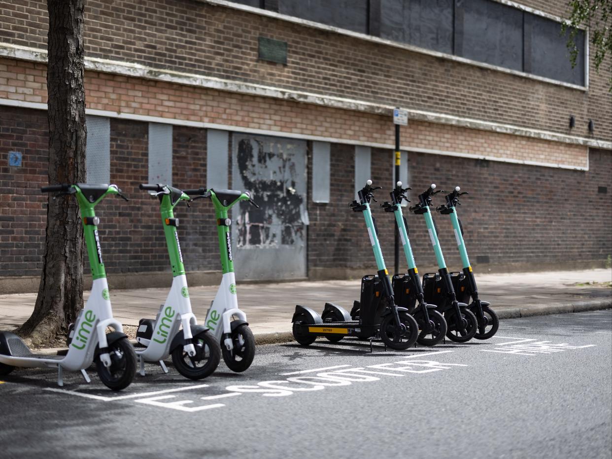 A row of both Lime (L) and Tier (R) electric scooters are seen in a parking bay on July 05, 2021 in London, England. (Getty Images)