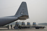 Tanks containing a solution of water and salt are loaded into a military plane at Subang Military airbase in Subang, Malaysia, Thursday, Sept. 19, 2019. Malaysian authorities plan to conduct a cloud-seeding operation to induce rain in an effort to ease the haze problem due to forest fires in neighboring Indonesia. (AP Photo/Vincent Thian)