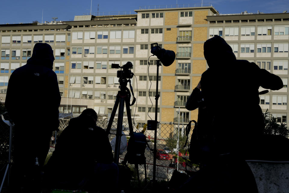 Miembros de los medios de comunicación se colocan afuera del Hospital Agostino Gemelli, en Roma, el jueves 30 de marzo de 2023. (AP Foto/Andrew Medichini)