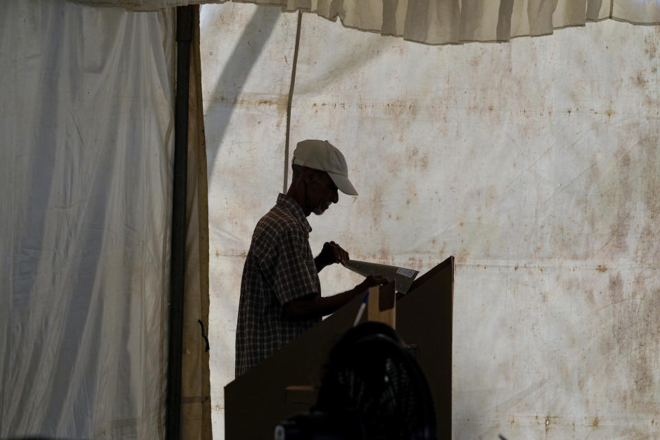 Un elector marca a sus candidatos en la boleta durante las elecciones generales en Santo Domingo, República Dominicana, el domingo 19 de mayo de 2024. (Foto AP/Matías Delacroix)