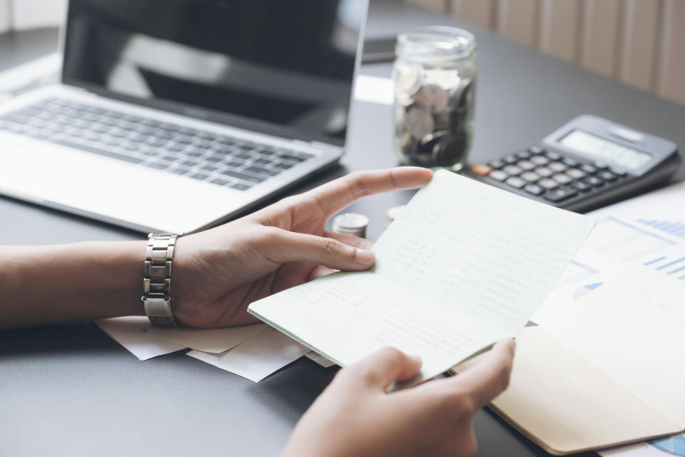 hand holding papers at a desk