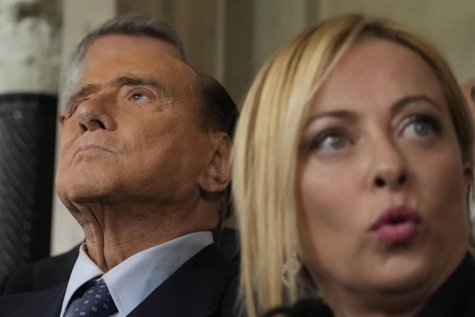 FILE - Brothers of Italy's leader Giorgia Meloni, right, talks to the press as Forza Italia president Silvio Berlusconi looks up at the Quirinale Presidential Palace after a meeting with Italian President Sergio Mattarella as part of a round of consultations with party leaders to try and form a new government, in Rome, Oct. 21, 2022. Berlusconi, the boastful billionaire media mogul who was Italy's longest-serving premier despite scandals over his sex-fueled parties and allegations of corruption, died, according to Italian media. He was 86. (AP Photo/Gregorio Borgia, File)