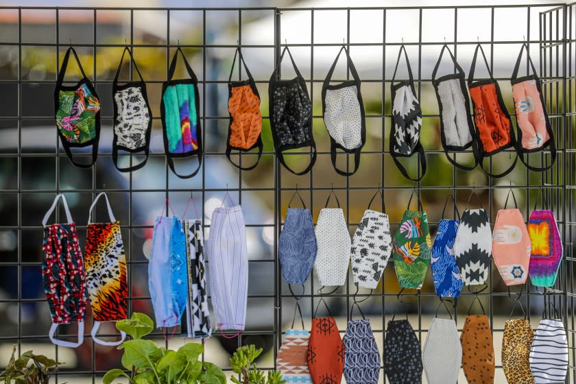 VENICE, CA - APRIL 18: Alisun Franson and Sadie Gilliam sell face masks from a stand in front of their story Amiga Wild in Venice. Venice, CA. (Irfan Khan / Los Angeles Times)