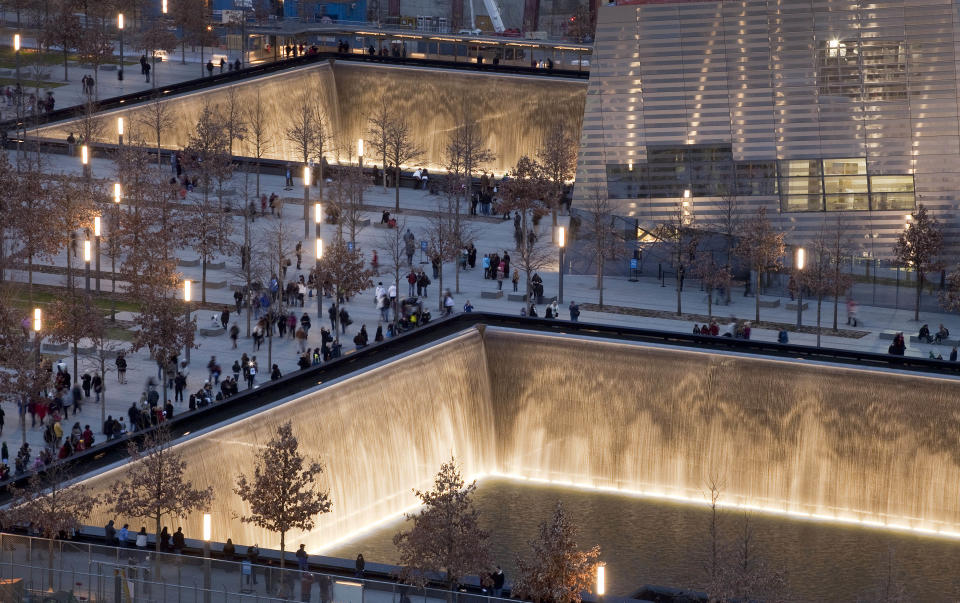 FILE - In this Dec. 20, 2011 file photo, visitors to the National September 11 Memorial in New York walk around its twin pools. The foundation that runs the memorial estimates that once the roughly $700 million project is complete, it will cost $60 million a year to operate. (AP Photo/Mark Lennihan, File)