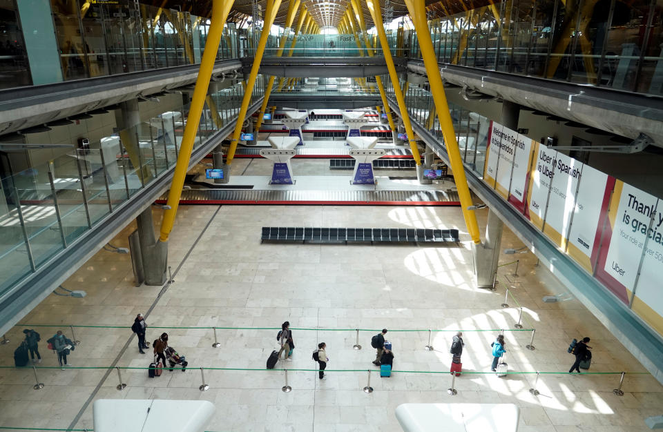 Los aterrizajes en el destino también han cambiado. Varios pasajeros hacen cola guardando la distancia de seguridad al llegar al Aeropuerto Adolfo Suárez-Madrid Barajas (España). (Foto: Juan Medina / Reuters).