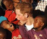 <p>Prince Harry makes faces at two boys, Mutsu (left) and Lintle (right), in the grounds of the Mants’ase children’s home on a return visit to Lesotho on April 24, 2006, in southern Africa. The prince was in the country to launch his new charity, Sentebale, which means “Forget me not,” in memory of his mother, Princess Diana. (Photo by Pool/Anwar Hussein Collection/Getty Images) </p>