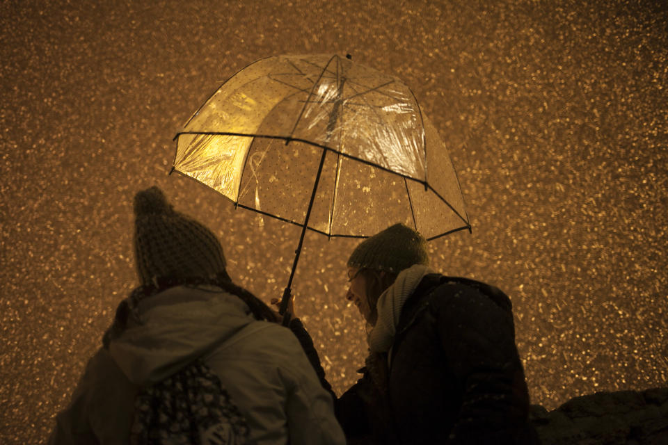 Women holding an umbrella look at snow coming down on the city of Ronda, southern Spain, Thursday, Jan. 19, 2017. The schools of Ronda, one of the most historical towns of Andalusia, suspended their classes Thursday and traffic has been interrupted on several highways due to the intense snowfall that has fallen during the night. A cold spell has reached Europe with temperatures plummeting far below zero. (AP Photo/Javier Gonzalez)