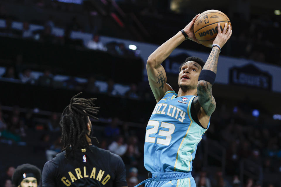 Charlotte Hornets guard Tre Mann (23) shoots over Cleveland Cavaliers guard Darius Garland during the first half of an NBA basketball game in Charlotte, N.C., Wednesday, March 27, 2024. (AP Photo/Nell Redmond)