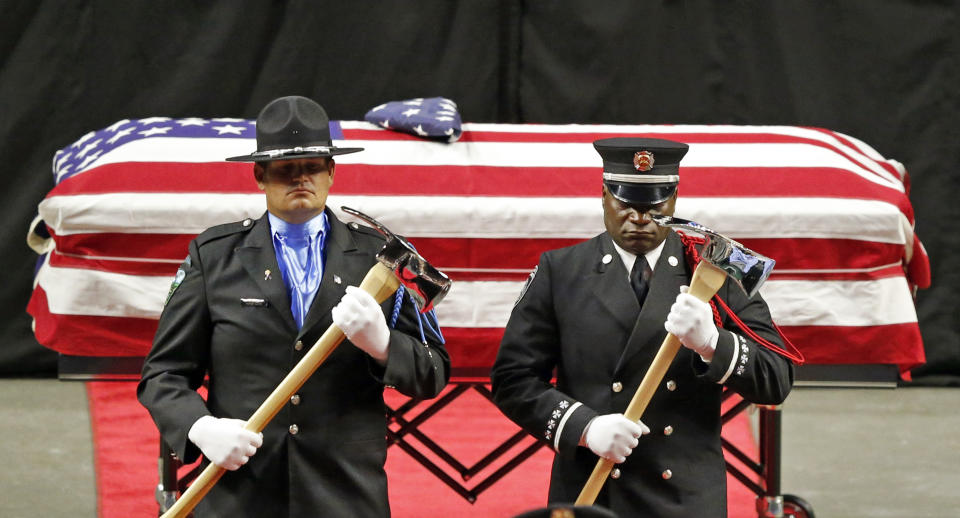 The Honor Guard stands at attention in front the casket of Battalion Chief Matt Burchett of the Draper Fire Department during funeral services Monday, Aug. 20, 2018, in West Valley City, Utah. Burchett died Aug. 13 from falling tree debris after a load of fire retardant was dropped on the area where he was working. (AP Photo/Rick Bowmer)
