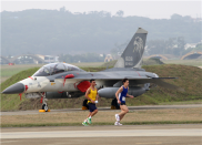 「跟飛機賽跑」路跑活動27日於空軍清泉崗基地舉行，跑者跑過機堡前的戰機，留下難得的影像。（軍聞社記者卓以立攝）