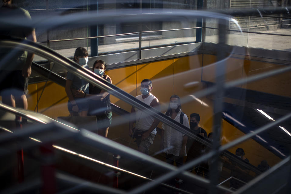 Personas con mascarillas para prevenir la propagación del coronavirus dentro de una estación de metro en Madrid, España, el martes 28 de julio de 2020. (AP Foto/Manu Fernández)