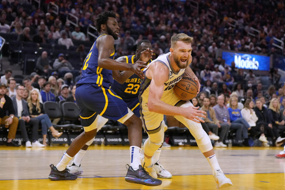 Sacramento Kings forward Domantas Sabonis (10) drives to the basket against Golden State Warriors forward Andrew Wiggins (22) during the first half of an NBA basketball game on Sunday, Oct. 23, 2022 in San Francisco. (AP Photo/Tony Avelar)