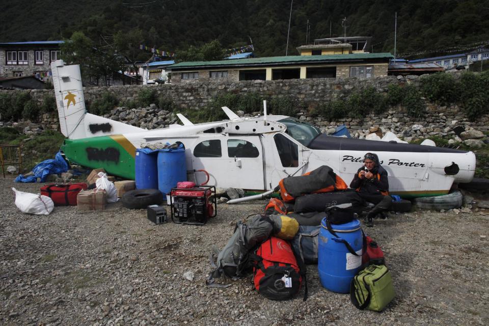 In this Friday, May 24, 2013 photo, an Italian climber waits at Lukla airport, Nepal. Carved out of side of a mountain, the airport was built by Sir Edmund Hillary in 1965, and at an altitude of 2,843 meters (9,325 feet) it has earned the reputation of being one of the most extreme and dangerous airports in the world. (AP Photo/Niranjan Shrestha)