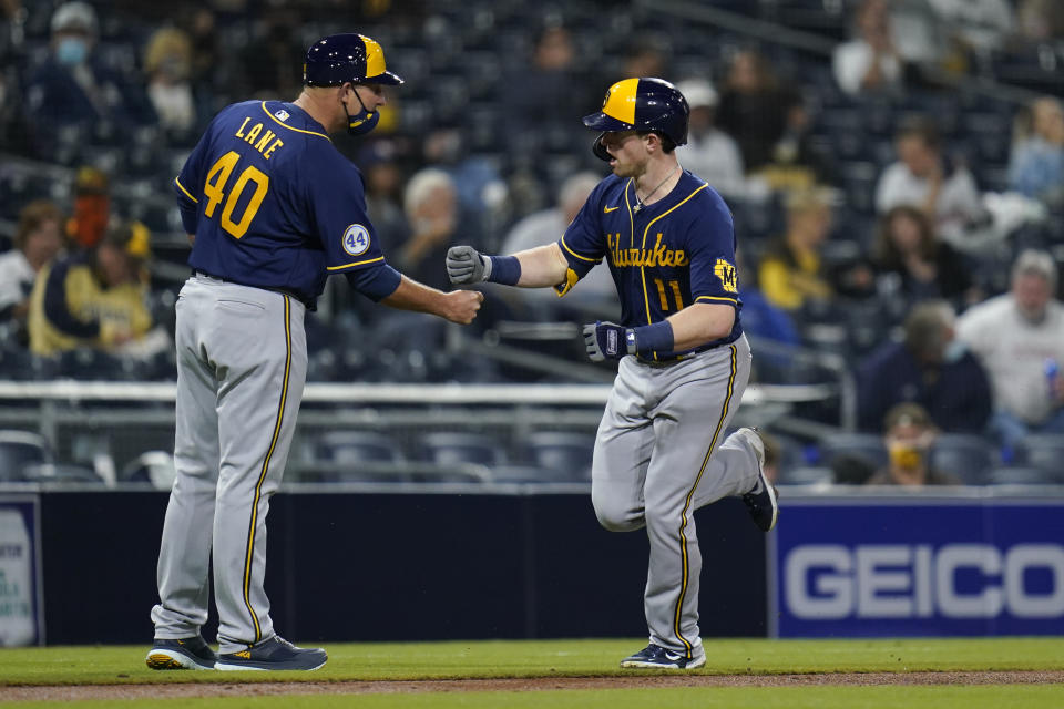 Milwaukee Brewers' Billy McKinney, right, is greeted by third base coach Jason Lane (40) after hitting a home run during the fifth inning of a baseball game against the San Diego Padres, Monday, April 19, 2021, in San Diego. (AP Photo/Gregory Bull)