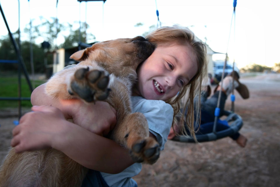 Talita Cohen is seen cuddling her puppy Bruiser on April 27, 2020 in Louth, Australia. With a population of approximately 29, residents of Louth on the Darling River in outback New South Wales are having very different experiences adjusting to restrictions in place due to COVID-19. (Photo by Mark Evans/Getty Images)