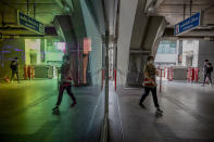 Commuters wearing face masks to protect themselves from the new coronavirus are reflected in a mirror at a skytrain station in Bangkok, Thailand, Friday, April 3, 2020. Thailand's prime minister announced a nationwide 10 p.m.-to-4 a.m curfew starting Friday to combat the spread of the coronavirus. The new coronavirus causes mild or moderate symptoms for most people, but for some, especially older adults and people with existing health problems, it can cause more severe illness or death. (AP Photo/Sakchai Lalit)