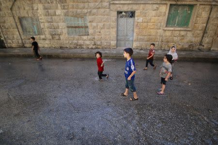 Children play with water from a burst water pipe at a site hit yesterday by an air strike in Aleppo's rebel-controlled al-Mashad neighbourhood, Syria, September 30, 2016. REUTERS/Abdalrhman Ismail