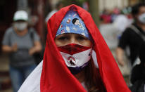 Nurses from the National Hospital protest for better salaries and security gear amid the COVID-19 pandemic outside the Economy Ministry in Asuncion, Paraguay, Monday, Oct. 26, 2020. (AP Photo/Jorge Saenz)