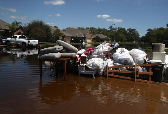 Damaged furniture and personal belongings sit on a flooded curb in Southeast Texas.