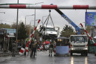 A damaged vehicle is removed from the site of a bomb explosion in Kabul, Afghanistan, Monday, March 30, 2020. A sticky bomb attached to the vehicle detonated, according to Firdaus Faramraz, spokesman for the Kabul police chief. (AP Photo/Rahmat Gul)