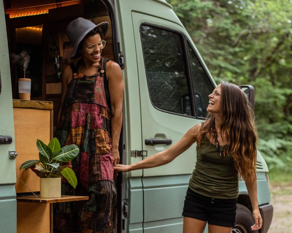 Abi and Nat hold hands while walking out of the van