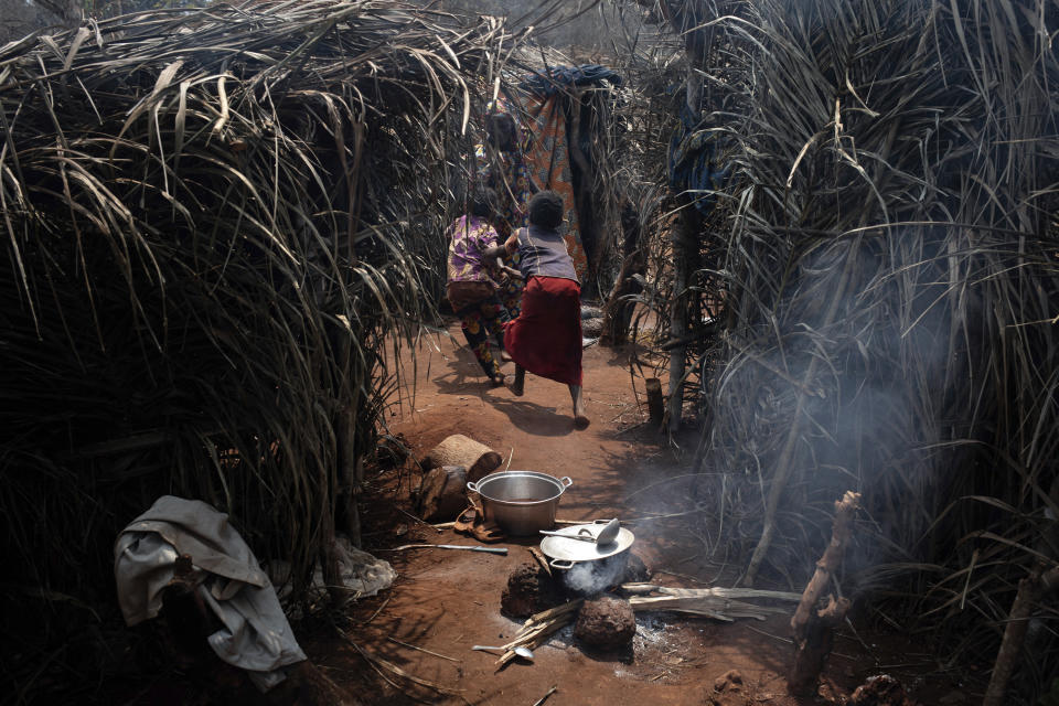 Two girls run between makeshift shelters in the village of Siwa, Central African Republic, Saturday Feb. 13, 2021. An estimated 240,000 people have been displaced in the country since mid-December, according to U.N. relief workers, when rebels calling themselves the Coalition of Patriots for Change launched attacks, causing a humanitarian crisis in the already unstable nation. (AP Photo/Adrienne Surprenant)