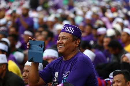 A supporter attends a rally to support the adoption of a strict Islamic penal code at Padang Merbok in Kuala Lumpur, Malaysia, February 18, 2017. REUTERS/Athit Perawongmetha